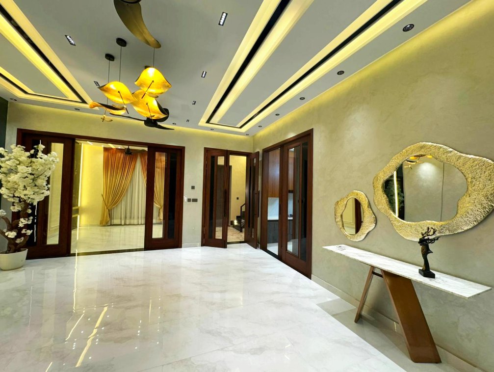 Gold pendant lit foyer with custom mirrors